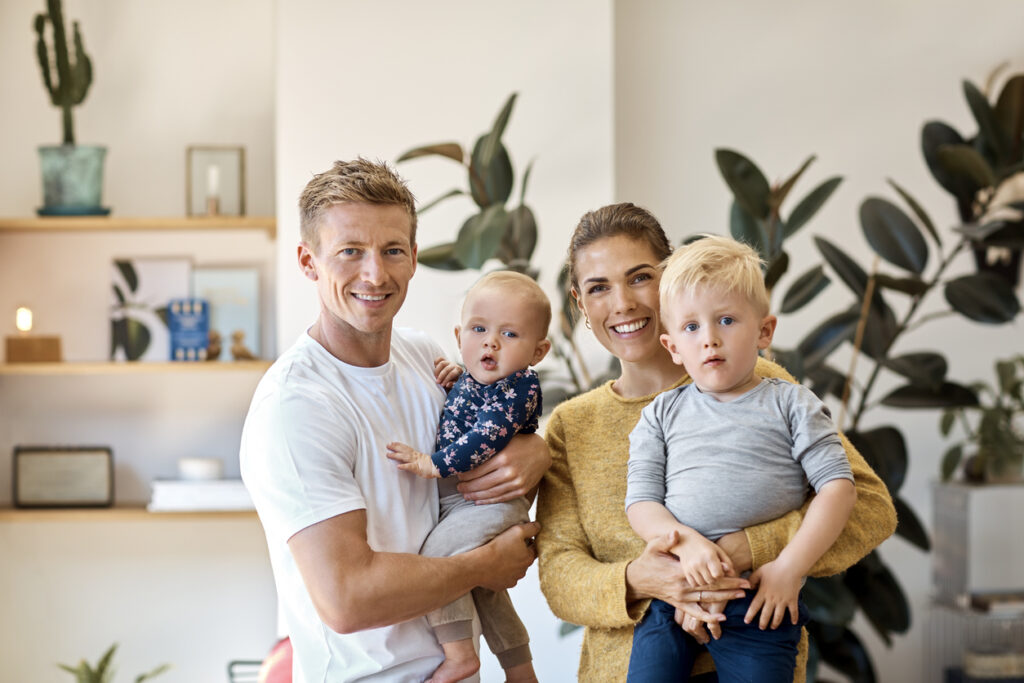 Happy parents carrying children at home Happy parents carrying children at home