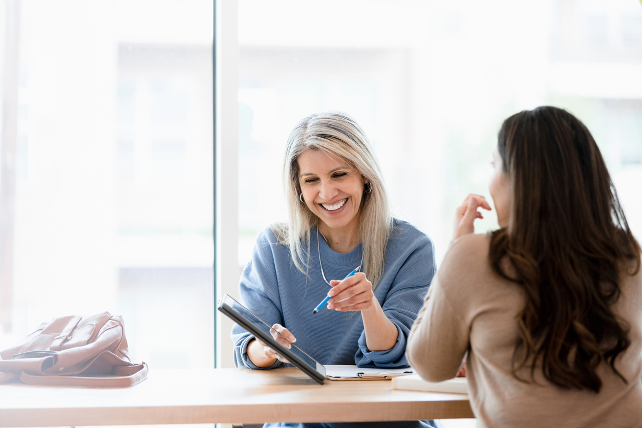 Female financial advisor reviews documents on digital tablet Psykiatrisk vård på althea Care
